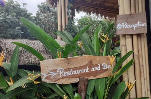 a sign for a restaurant and bar in a garden at Tribal Village Homestay & Trekking in Banlung