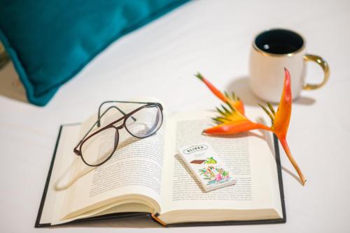 a book with a pair of glasses and a cup of coffee at Colina de Montalva in Tarapoto
