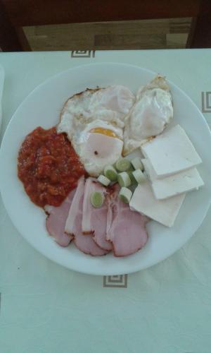 een bord met vlees, eieren en kaas bij CASUTA MAGICA in Păuşeşti-Măglaşi