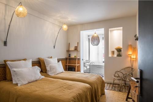 ein Schlafzimmer mit 2 Betten und ein Badezimmer in der Unterkunft Maison Volver in Arles