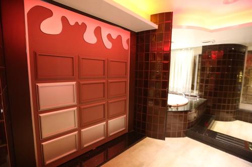 a bathroom with a red wall with a toilet and a sink at Yosemite Motel - Taiyuan Branch in Taichung