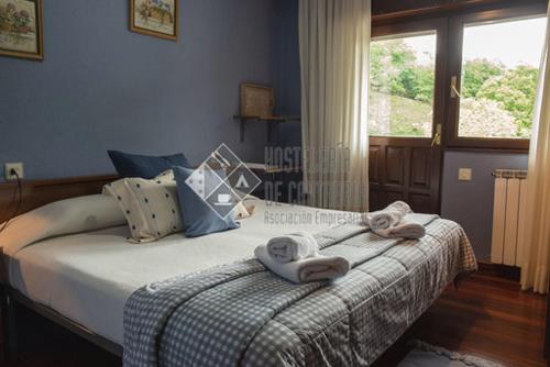 1 dormitorio con 1 cama con toallas en Hostal casa lucas en Los Tojos