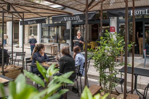 a group of people sitting at a table in a restaurant at Maison Volver in Arles