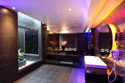 a bathroom with purple lighting and a sink at Yosemite Motel - Taiyuan Branch in Taichung