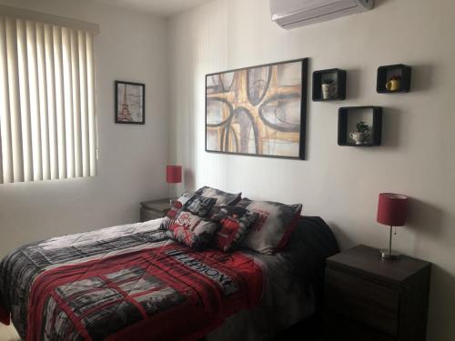 a bedroom with a bed and a painting on the wall at Beach Haus-Punta Estrella in Playa del Carmen