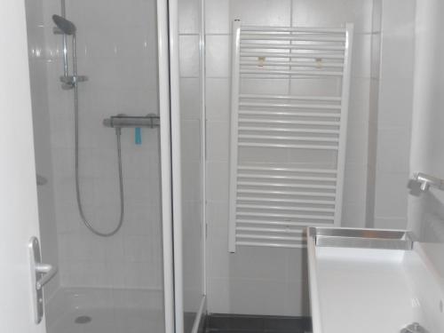 een witte badkamer met een douche en een wastafel bij Maison centre bourg Port-Bail in Portbail