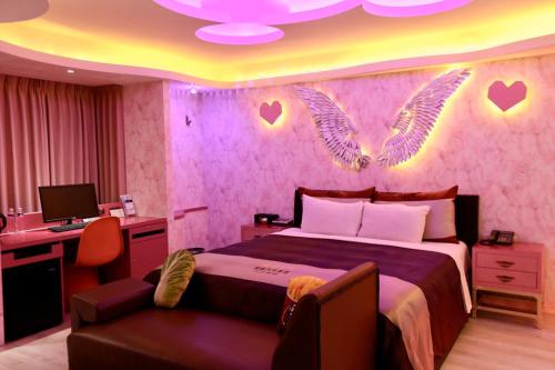 a bedroom with a bed with wings on the wall at Yosemite Motel - Taiyuan Branch in Taichung