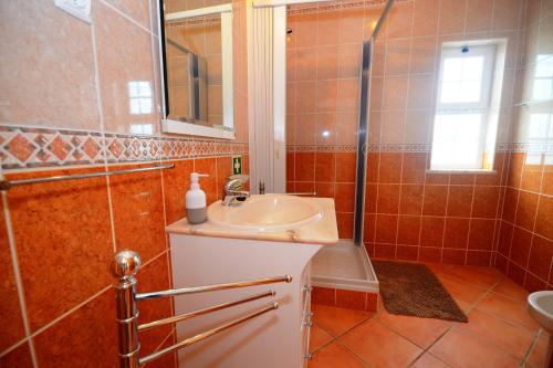 a bathroom with a sink and a shower at Villa Casa das Amendoeiras in Alcantarilha
