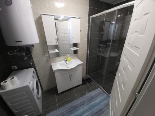 a bathroom with a toilet and a sink and a shower at XXL APARTMENTS CiTY CENTAR in Bitola