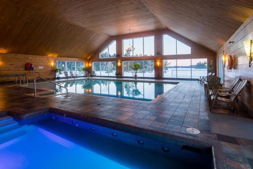 an indoor swimming pool in a house with a large building at Pourvoirie du Lac Blanc in Saint-Alexis-des-Monts