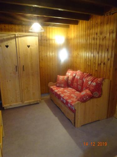- un canapé dans une pièce dotée de murs en bois dans l'établissement La Bresse Hautes Vosges Chalet 