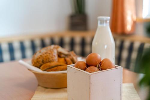 a box of eggs and a bowl of bread and a bottle of milk at Residence Kahn in Santa Maddalena in Casies