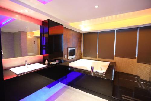 a bathroom with two sinks and a large tub at Yosemite Motel - Taiyuan Branch in Taichung