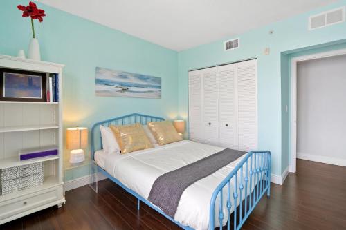 a blue bedroom with a bed and a tv at Welworth condo units Miami Beach in Miami Beach