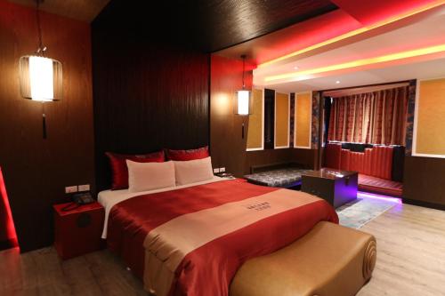 a hotel room with a large bed and a living room at Yosemite Motel - Taiyuan Branch in Taichung