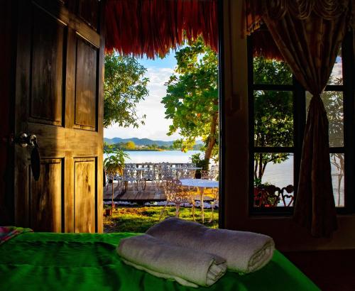 a bedroom with a window with a view of the water at Mayan Spirit in Flores