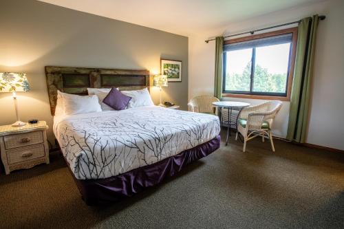 a bedroom with a large bed and a large window at Open Hearth Lodge in Sister Bay