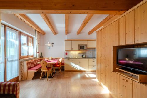 a kitchen and living room with a television and a table at Residence Kahn in Santa Maddalena in Casies