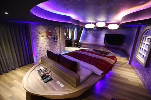 a bedroom with a bed in a room with purple lighting at Yosemite Motel - Taiyuan Branch in Taichung