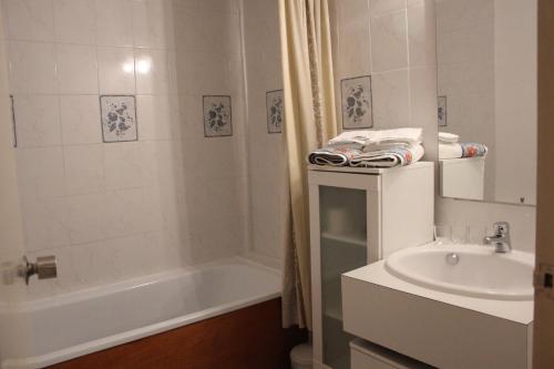 Un baño blanco con bañera y lavabo. en Anglet face à l'océan, en Anglet