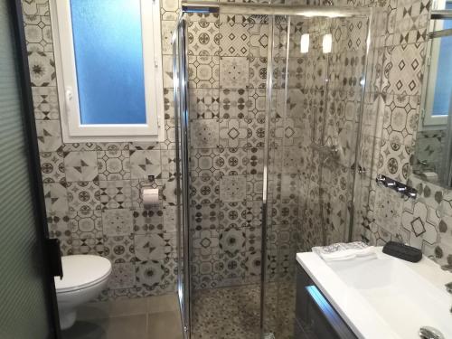 een badkamer met een douche, een toilet en een wastafel bij Le petit poucet in La Bourboule