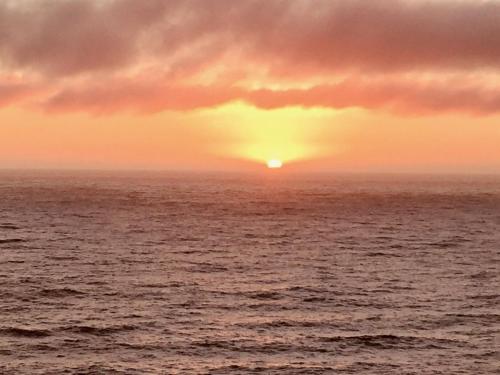 a sunset over the ocean with the sun setting at Tunquen Magico in Tunquen