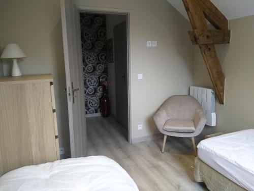 een slaapkamer met een bed en een stoel in een kamer bij Le petit poucet in La Bourboule