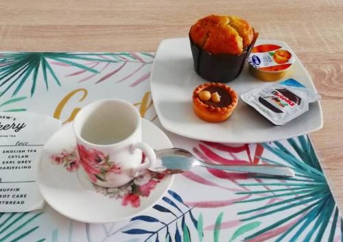a plate with a cup of coffee and a muffin at La finestra sulla fiera in Bologna