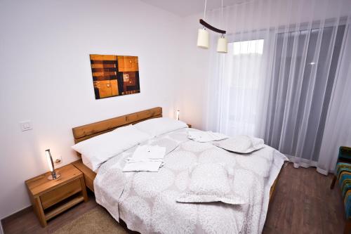 sypialnia z dużym białym łóżkiem z ręcznikami w obiekcie Apartment I&I w Poreču