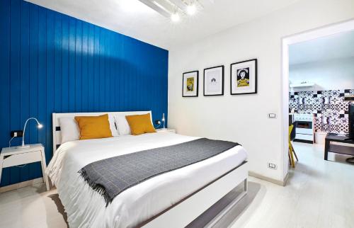 サン・ペッレグリーノ・テルメにあるDesign Suite Cavagnaの青い壁のベッドルーム1室(大型ベッド1台付)