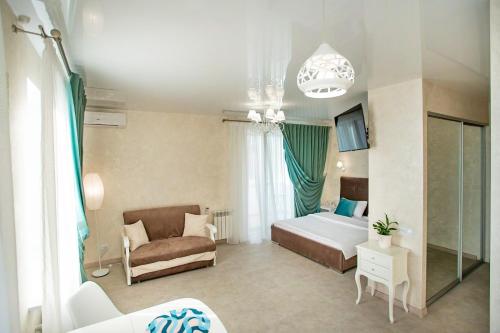 um quarto com uma cama e um sofá num quarto em Студия Luxury в центре em Mykolaiv