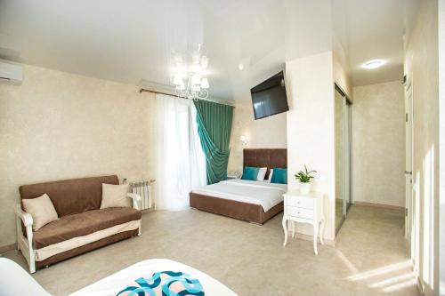 a living room with a bed and a couch in a room at Студия Luxury в центре in Mykolaiv