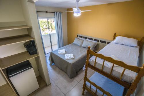 ein kleines Schlafzimmer mit einem Bett und einer Couch in der Unterkunft Litoral Hotel Arroio do Sal in Arroio do Sal