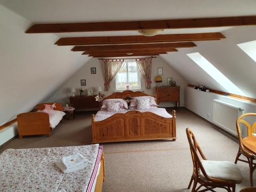 een slaapkamer op zolder met 2 bedden en een tafel bij Ubytování za kapličkou in Třeboň
