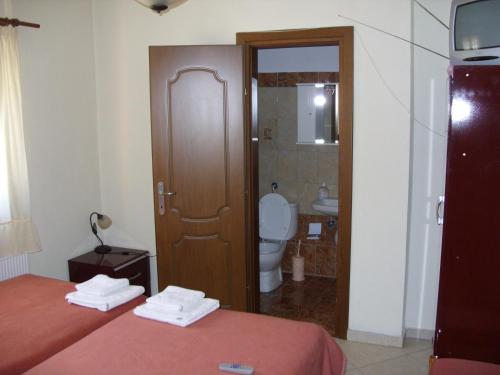 een hotelkamer met een bed en een badkamer met een toilet bij Frida in Antartiko