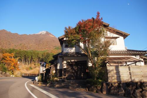 a house sitting on the side of a road at Yufuin Country Road Youth Hostel in Yufuin