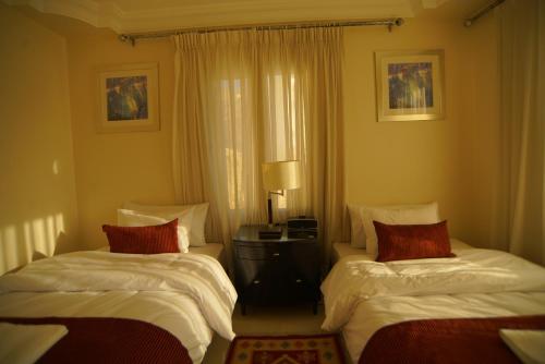 a bedroom with two beds and a window at Over Mountains Hotel in Wadi Musa