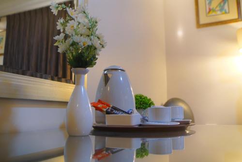 a table with a vase and a plate with flowers at Over Mountains Hotel in Wadi Musa