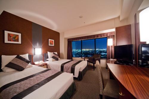 a hotel room with two beds and a large window at Shin Yokohama Prince Hotel in Yokohama