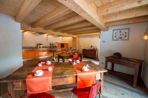 a living room with a wooden table and a kitchen at Bed & Breakfast Alchemilla in Gressoney-la-Trinité