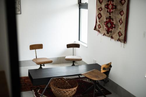 2 sillas y una mesa en una habitación con alfombra en Kamin Kanazawa, en Kanazawa