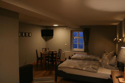 Schlafzimmer mit einem Bett, einem Tisch und einem Fenster in der Unterkunft Haus Brunnenkunst in Arnstadt
