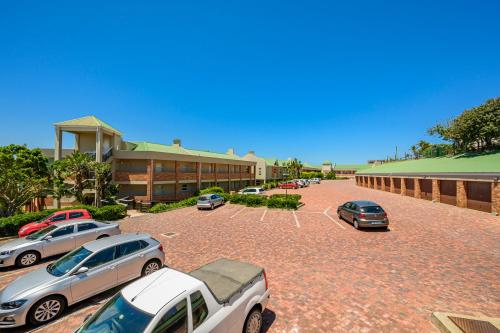 a parking lot with cars parked in front of a building at Brookes Hill Suites Luxury Apartment 124 in Port Elizabeth