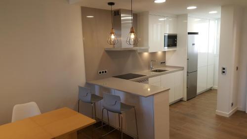 a kitchen with a counter and a sink and a table at Pinien Platz in Cala Ratjada