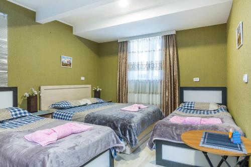 a hotel room with two beds and a table at Guest house poligloti in Tʼelavi