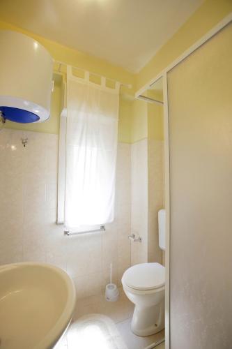 a bathroom with a white toilet and a sink at Appartamento Topazio in Letojanni