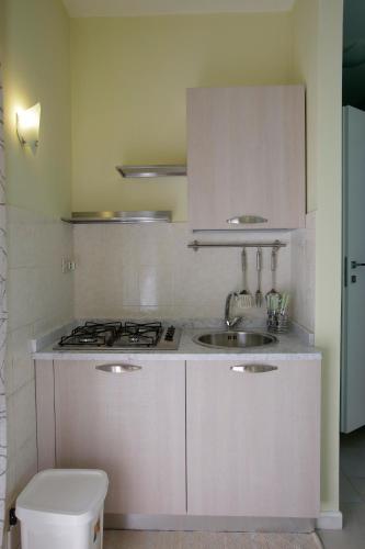 a white kitchen with a sink and a stove at Appartamento Topazio in Letojanni