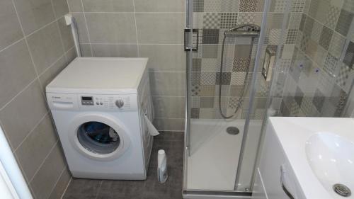 La salle de bains est pourvue d'un lave-linge et d'une douche. dans l'établissement Grand appartement T3/T4 proche des berges du Cher, à Montluçon