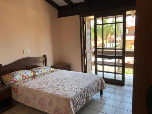 um quarto com uma cama e uma porta de vidro deslizante em Vô Doríbio em Torres