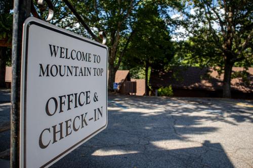 a sign that says welcome to mountain top office and check in at Mountain Top Inn and Resort in Warm Springs
